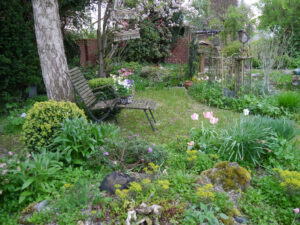 Blick vom Steingarten bis zur roten Klinkermauer am anderen Gartenende in Wurzerlsgarten