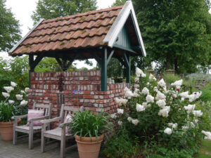 Selbst gemauerter Sitzplatz zwischen Rispenhortensien im Garten Anneliese Kisfeld