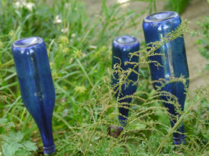 Der Bach ist nicht blau in Inge Feckls Garten, aber die Flaschendeko.